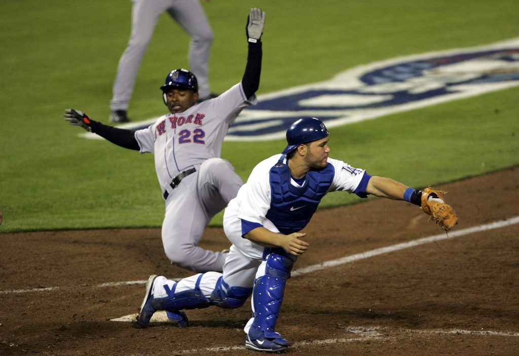 Michael Tucker slides past Russell Martin for the go-ahead run in the sixth inning of Game 3. (Stephen Dunn/Getty Images)