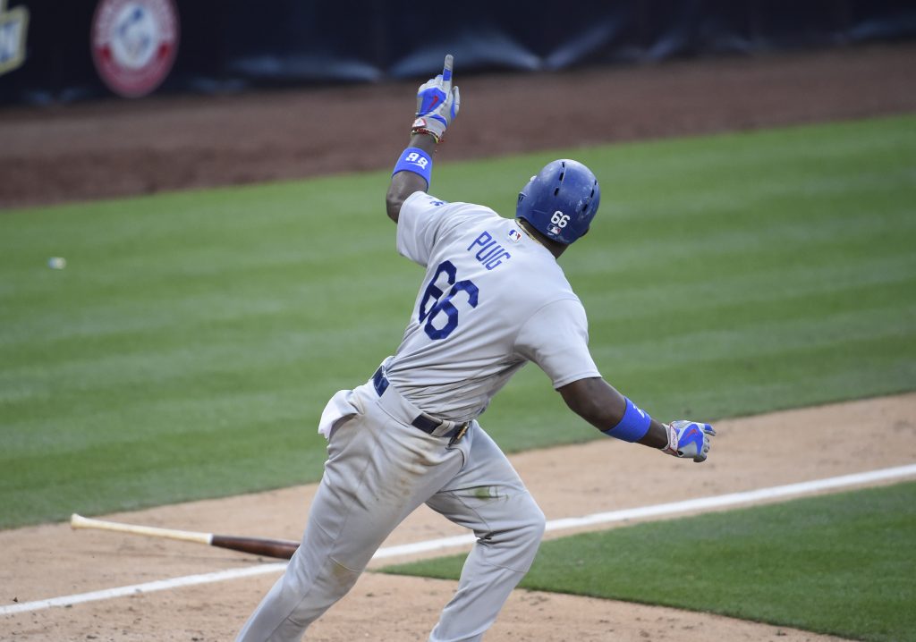 Yasiel Puig points back to the dugout after hitting a tiebreaking two-run single in the 17th inning. (Denis Poroy/Getty Images)